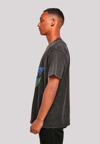 Dark gray cotton t-shirt featuring a colorful graphic design on the front, short sleeves, and a relaxed fit with a slightly worn texture.