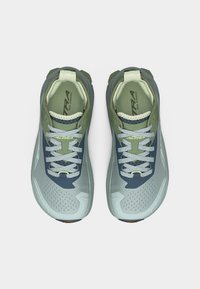 Paire de chaussures de trail vertes et bleues avec lacets gris, bouts perforés et marquage "Altra" visible à l'intérieur et sur la languette.