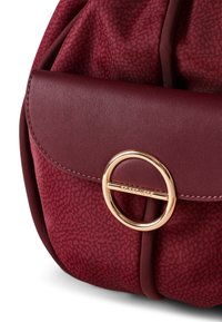 Borsa bordeaux con patta in pelle liscia, hardware circolare dorato e corpo in tessuto testurizzato con un motivo sottile. Incluso tracolla regolabile.