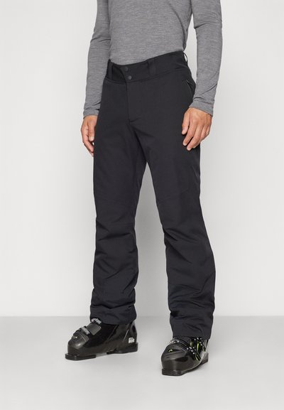 Μαύρο παντελόνι σκι κατασκευασμένο από αδιάβροχο υλικό, με ίσια γραμμή, δύο τσέπες με φερμουάρ και ζώνη στη μέση με κουμπί.