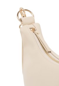 Borsa a tracolla in pelle beige con una texture liscia, caratterizzata da una cerniera dorata, un tirante per la cerniera e dettagli in metallo.