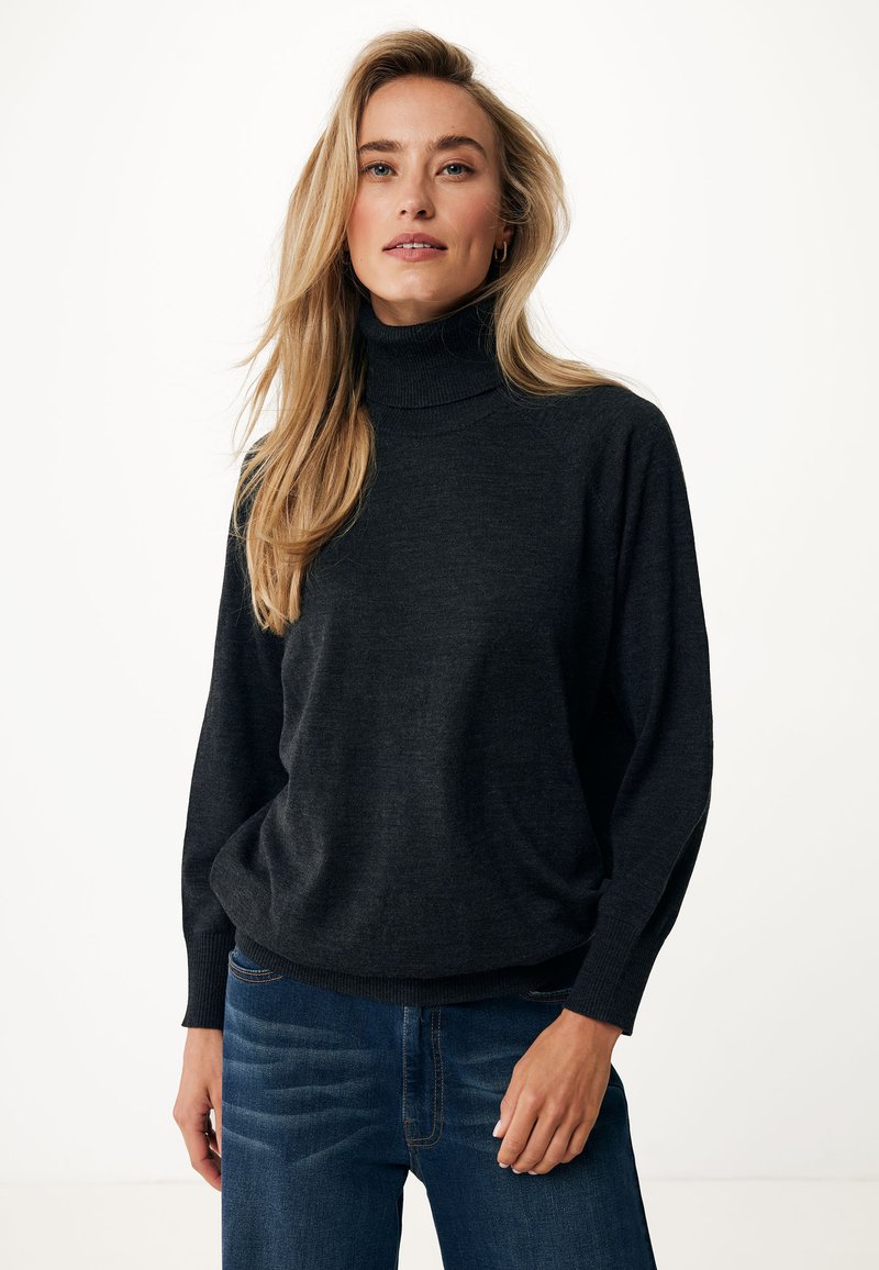 Maglione a collo alto grigio scuro realizzato in materiale morbido, con una vestibilità comoda e polsini a costine, abbinato a jeans di denim blu.