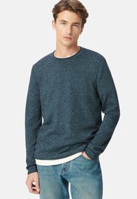 Marineblaues langärmeliges Crewneck-Sweatshirt aus strukturiertem Stoff, mit taillierter Silhouette, rundem Halsausschnitt und einem schichtartigen weißen Shirt am Saum.