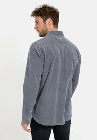 Grau Cordhosenhemd mit langenÄrmeln, Knopfmanschetten und spitzem Kragen. Auffällige Textur und lockere Passform, mit abgerundetem Saum.