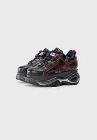 Sneakers neri chunky con accenti rossi e grigi, caratterizzati da una tomaia in pelle, pannelli testurizzati e una suola in gomma spessa con modelli di aderenza.