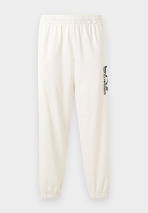 Lys beige joggebukser med elastisk midjebånd og elastiske mansjetter. Har en svart trykt logo på venstre ben. Myk stoffkvalitet.