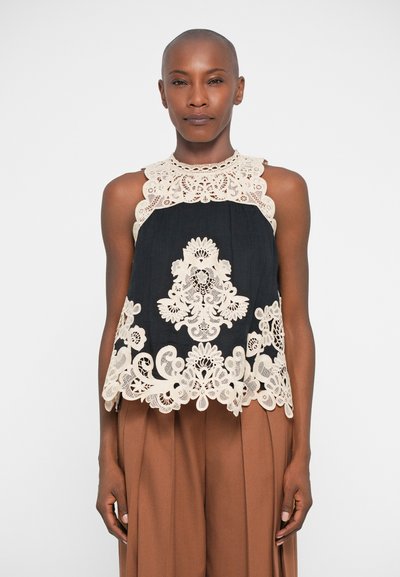 Zwarte mouwloze top met intrigerende beige kantdetails rond de halslijn en zoom, die een bloemenpatroon vormen. Geweven stof.