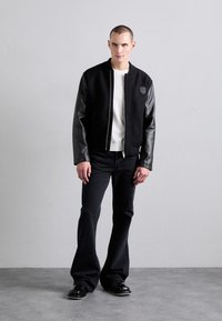EYTYS CYRUS RAVEN - Flared Jeans - black