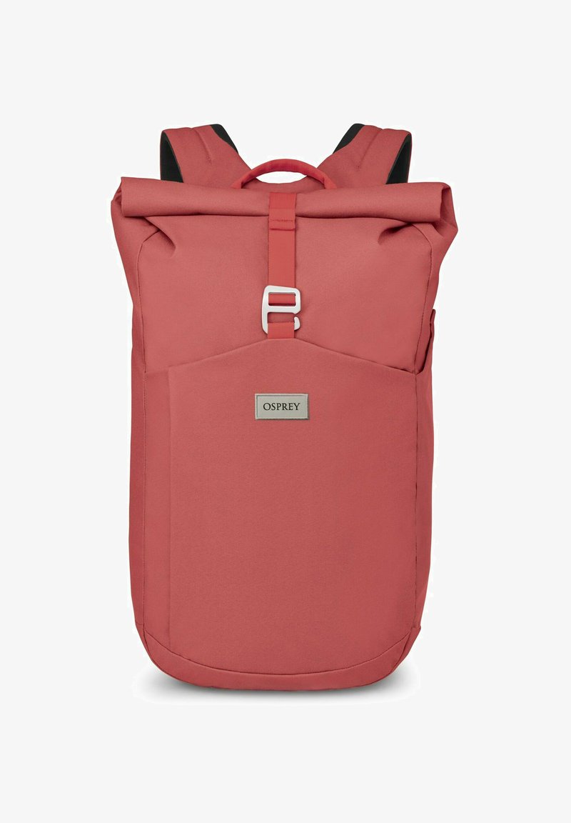 Mochila de color rosa con diseño de parte superior enrollable, correas ajustables y un bolsillo frontal. Presenta una etiqueta de marca plateada y está fabricada con un tejido duradero.