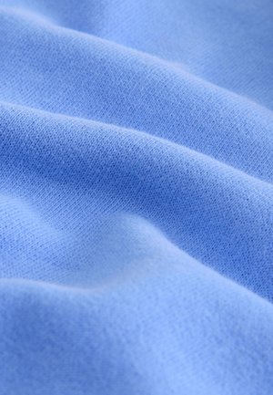 Tela azul suave y ligera con una textura lisa, que presenta sutiles variaciones de tono y un fino patrón tejido.