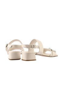 Weiße Sandalen mit Blockabsatz, die ein breites Riemchen, einen dünnen Knöchelriemen mit Schnalle und eine glatte Lederoberfläche aufweisen.
