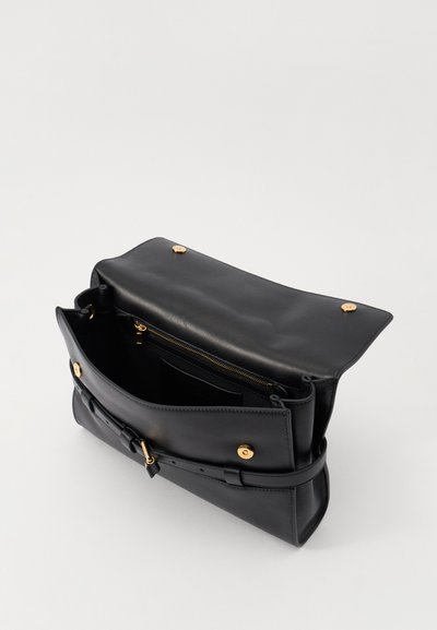 Sac à main en cuir noir avec une texture lisse, présentant des accessoires en or, un compartiment zippé et une fermeture à rabat avec un détail de boucle.