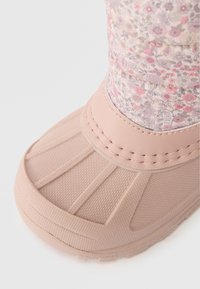 Ροζ αδιάβροχο μποτάκι με �υφασμάτινη σόλα από καουτσούκ, διαθέτοντας επάνω μέρος από υφασμάτινο με floral σχέδιο. Στρογγυλή μύτη και ραφές λεπτομέρειας.