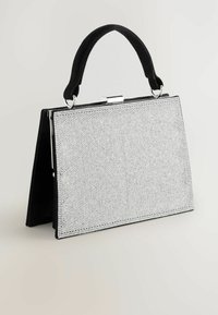 Melna rokassoma ar teksturētu sudraba sekvīru priekšpusi un melnu zamšu rokturi, ar sudraba sprādzi un strukturētu dizainu.