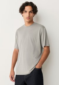 Light grey short-sleeve t-shirt featuring a round neckline and a relaxed fit. Fabric appears smooth, without visible patterns or textures.