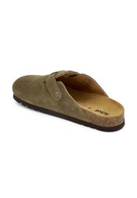 Chaussure à enfiler en daim vert olive avec un bout arrondi, une sangle réglable, une semelle en liège et une semelle en caoutchouc texturé pour l'adhérence.