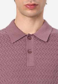 Light purple knit polo shirt featuring a zigzag texture, a collared neck, and two button closures at the front.