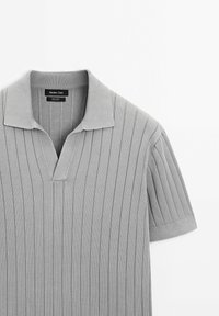 Gray ribbed polo shirt with a V-neck and short sleeves. Features a flat collar and textured fabric with vertical stripes. Brand label visible.