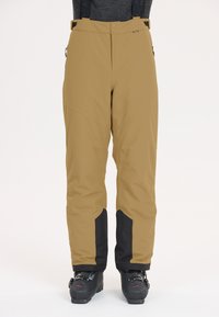 Ski broeken in beige met zwarte accenten onderaan, met een relaxte fit, verstelbare banden en ritszakken voor functionaliteit.