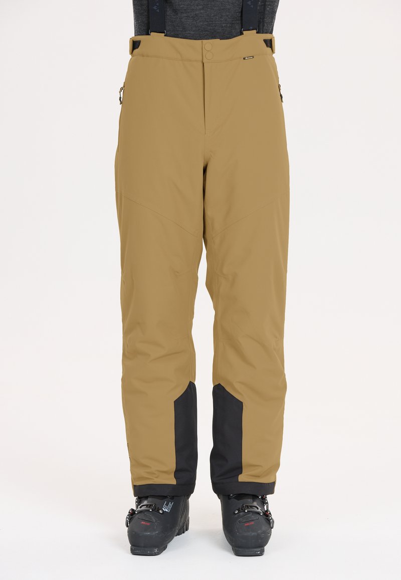 Ski broeken in beige met zwarte accenten onderaan, met een relaxte fit, verstelbare banden en ritszakken voor functionaliteit.