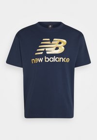 Navyblå bomullströja med en guldig metallisk "new balance"-logotyp och varumärkesinitialer. Kortsleeved, rundad halsdesign och vanlig passform.