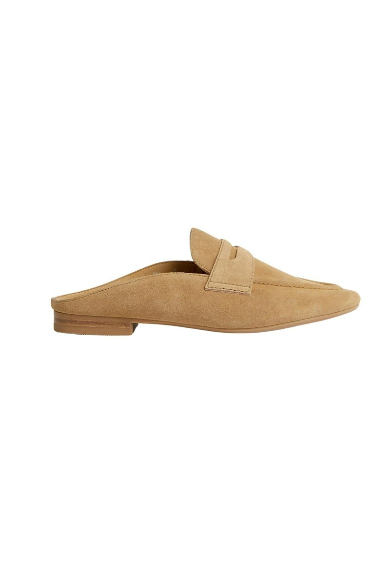 Mocassini slip-on in suede beige con tacco basso, caratterizzati da un'accento cucito e una punta rotonda. Texture liscia con dettagli minimi.