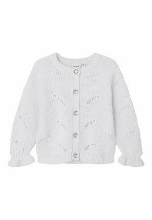 Valkoinen neulottu neuletakki pyöreällä kaula-aukolla, napillinen etukappale ja koristeelliset hopeiset napit. Mallissa on teksturoidut aaltoilevat kuviot ja resorit hihansuissa.