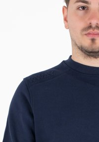 Felpa blu navy con scollatura rotonda e ricamo a trama "WAY" sulla spalla. Il tessuto è morbido e leggermente texturizzato.