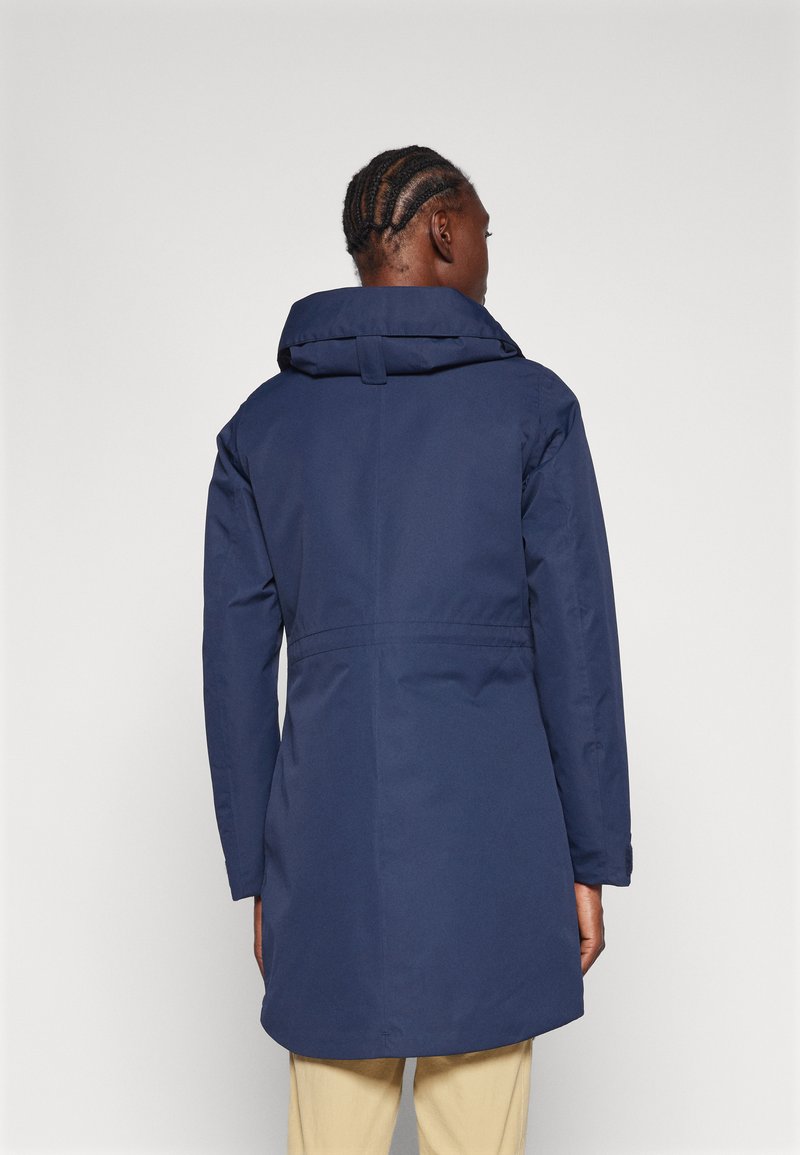 Manteau imperméable bleu marine avec une grande capuche ajustable, tissu texturé et taille cintrée. Présente une coupe droite et des manches longues.