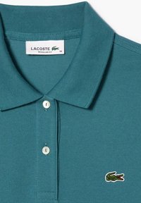 Teal Lacoste polo skjorte i regular fit med to hvide knapper og grønt krokodille-logo på brystet, størrelse 36.