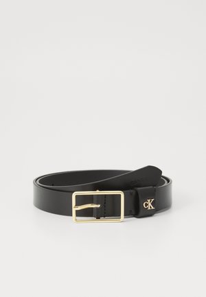 Cintura in pelle nera con una fibbia rettangolare dorata lucida. Presenta un'estremità ad anello e un piccolo logo "CK" impresso sulla cinghia.