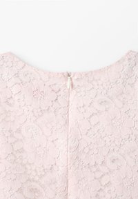 Lichtroze kanten jurk met een bloemenpatroon, voorzien van een rits aan de achterkant met een klein wit trekkoord en een ronde halslijn.