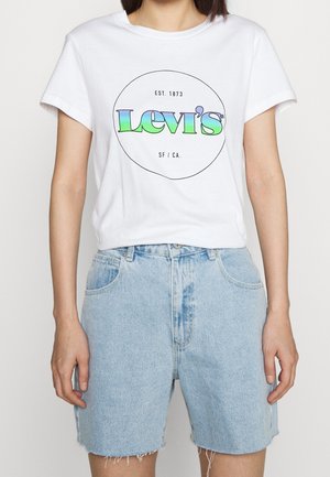 T-shirt en coton blanc avec un logo "Levi's" multicolore. Associé à un short en denim bleu clair aux bords effilochés et avec des poches devant.