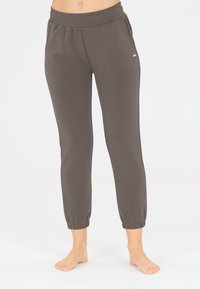 Pantalon de jogging gris avec une taille élastique et des chevilles côtelées. Fabriqué dans un matériau doux avec une texture lisse et des accents de design minimalistes.