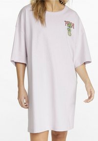 Fliederfarbenes übergroßes T-Shirt-Kleid mit kurzen Ärmeln, auf der linken Brust mit einem bedruckten Ananas- und Textdesign. Weiche Baumwolltextur.