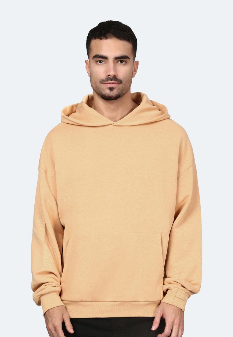 Felpa beige realizzata in morbido tessuto, con una grande tasca frontale, cappuccio con cordoncino e polsini a costine. Design semplice e dalla vestibilità rilassata.