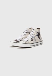 High-top sneakers with a white and black tie-dye canvas upper, white laces, and rubber soles featuring a textured toe cap and black stripe.