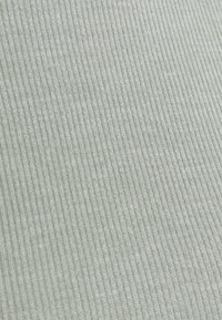 Light green ribbed textile with a soft texture, featuring evenly spaced vertical stripes across the surface.