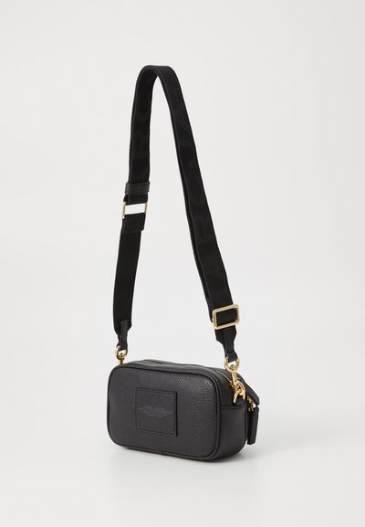 Rektangulær sort lædertaske med en tekstureret overflade, detaljer i guldhardware og en vævet strap med logoet i sort.