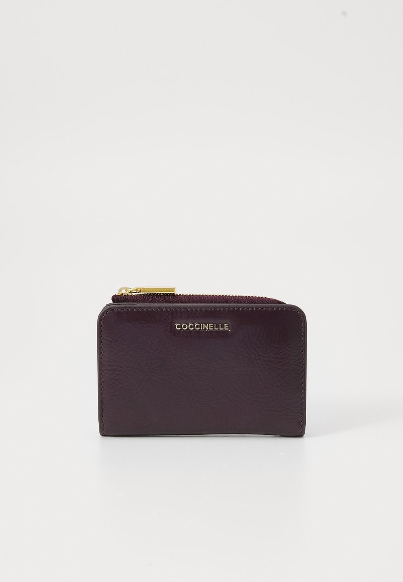 Portefeuille en cuir violet foncé avec une texture subtile, doté d'une fermeture éclair dorée et d'un détail de logo à l'avant. Forme rectangulaire compacte.