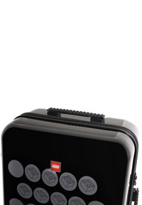 Black hard-shell case featuring LEGO brick print, rounded edges, sturdy zipper, and a textured top handle with classic LEGO stud design.