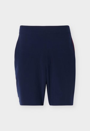 Mørkeblå treningsshorts med elastisk midjebånd og en diskret rød stripe på siden, vist flatt på en hvit bakgrunn.