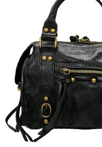 Sac à main en cuir noir avec une finition texturée, accents en matériel doré, poches zippées et détails à frange sur les côtés.