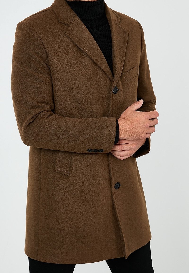Brauner Wollmantel mit taillierter Passform, Ein-Knopf-Verschluss, Reverskragen und Brusttasche. Strukturierter Stoff und klassische Designelemente.