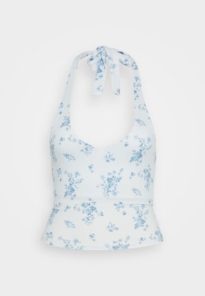 Top azzurro chiaro a halter realizzato in un tessuto morbido, con una stampa floreale di un blu più scuro. Ha un design aderente con orlo peplum e dettaglio con lacci.