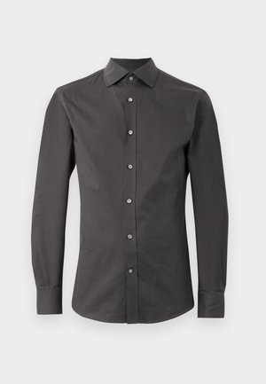 Chemise à manches longues gris foncé en tissu lisse, dotée d'un col pointu, de boutons sur le devant et d'une coupe ajustée. Aucun motif ni accent présent.
