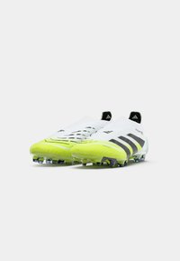 Crampons de football blancs avec des rayures noires, dotés d'une tige texturée, d'un bout jaune vif et de crampons multicolores pour l'adhérence.