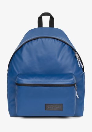 Sac à dos Eastpak bleu avec une poche zippée à l'avant, une poignée noire et des tirettes blanches sur un fond blanc uni.