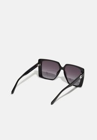 Ochelari de soare supradimensionați, de culoare neagră, cu ramă pătrată, lentile gradient de nuanță purpurie și brațe elegante, înguste, cu un accent subtil al logo-ului.
