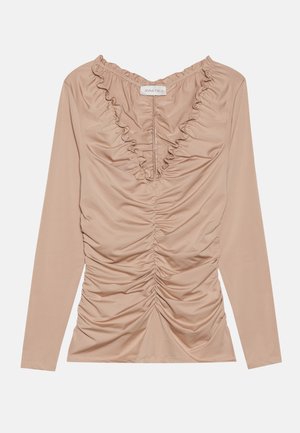 Maglietta a maniche lunghe in beige chiaro, caratterizzata da un design arricciato con un collo ondulato. Tessuto morbido ed elastico con una silhouette aderente.